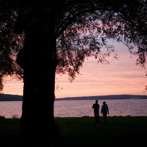 image of two people at sunset in front of a lake.
